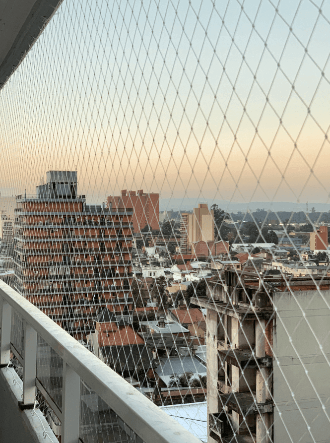 Red de seguridad instalada en balcón urbano al atardecer - Grupo Redes Tucumán y CABA